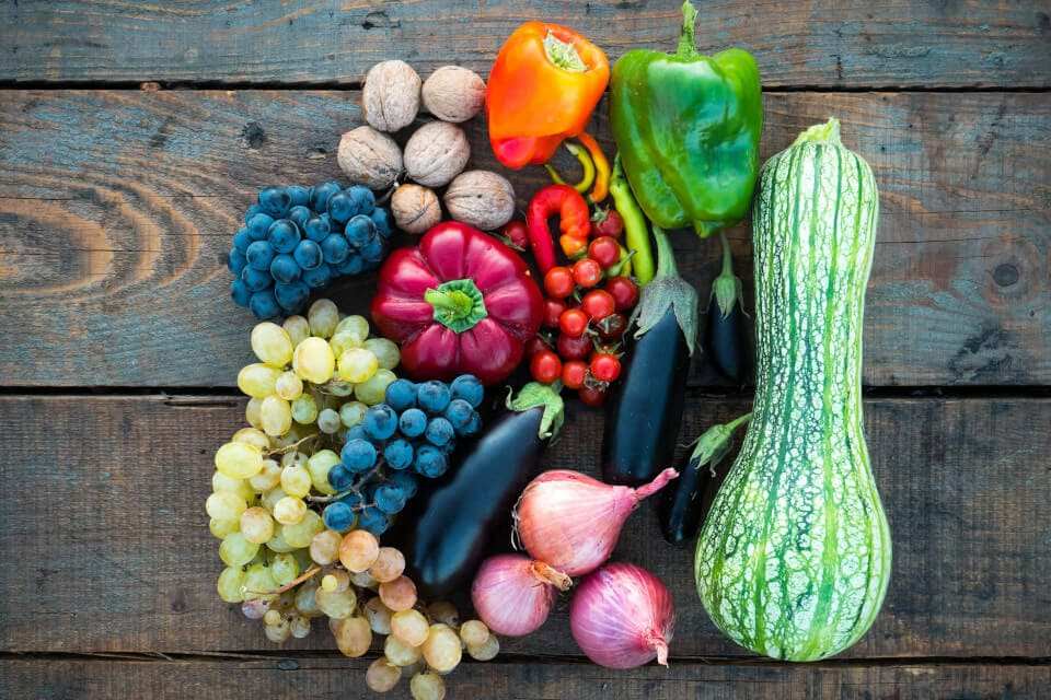 Cosa vuol dire biologico e quali sono i principi dell'agricoltura biologica (assortimento di frutta e di ortaggi su un tavolo di legno)